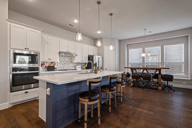 3204 Maplewood Dr, Mckinney, TX 75071 - kitchen with stainless steel appliances, dark wood finished floors, white cabinetry, tasteful backsplash, and recessed lighting
