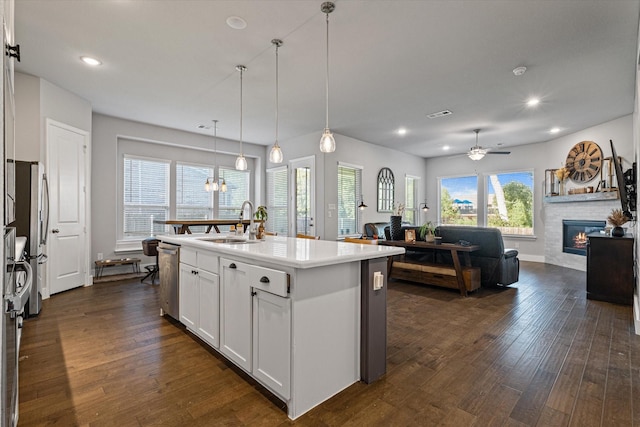 3204 Maplewood Dr, Mckinney, TX 75071 - kitchen featuring a glass covered fireplace, dark wood-style flooring, open floor plan, a ceiling fan, and white cabinets