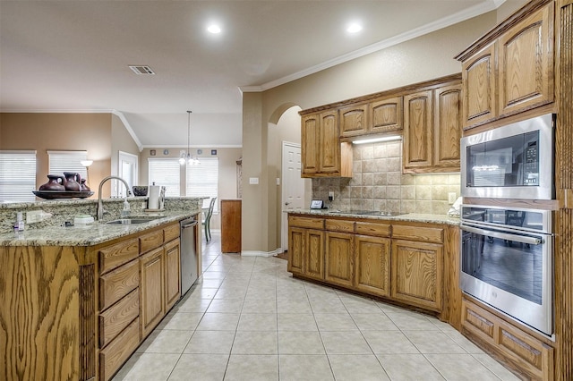 2134 Lorrie Ln, Weatherford, TX 76087 - kitchen with stainless steel appliances, backsplash, a sink, light stone countertops, and brown cabinetry