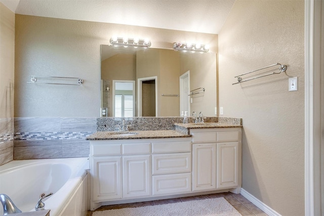 2134 Lorrie Ln, Weatherford, TX 76087 - full bathroom with double vanity, a jetted tub, tile patterned floors, and a textured wall