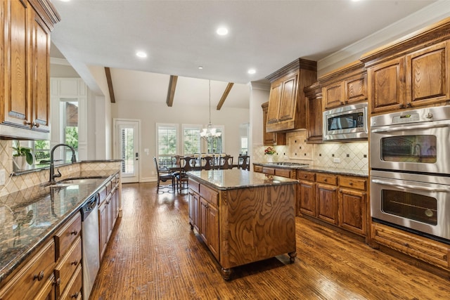 305 Crestfield Ct, Sunnyvale, TX 75182 - kitchen with appliances with stainless steel finishes, a sink, brown cabinetry, dark wood-type flooring, and recessed lighting