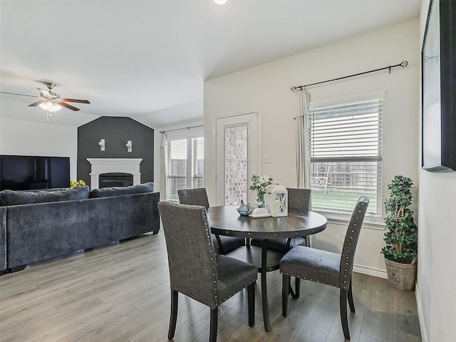 505 Maverick St, Anna, TX 75409 - dining room with light wood-style flooring, ceiling fan, lofted ceiling, a fireplace, and baseboards