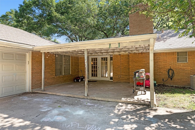 2118 Wooded Acres Dr, Waco, TX 76710 - view of patio / terrace with french doors, a garage, and driveway