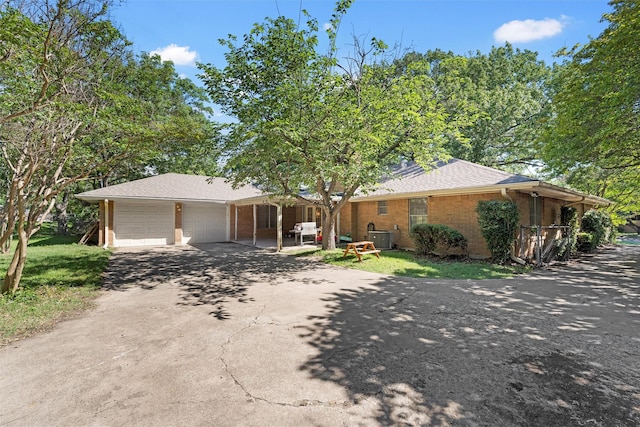 2118 Wooded Acres Dr, Waco, TX 76710 - ranch-style home featuring driveway, cooling unit, a garage, brick siding, and roof with shingles