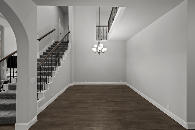 612 Wildriver Trl, Fort Worth, TX 76131 - unfurnished dining area with a chandelier, stairway, dark wood-type flooring, and arched walkways