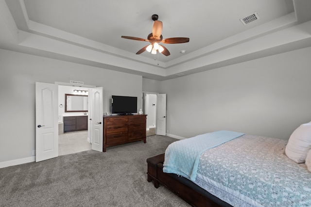 612 Wildriver Trl, Fort Worth, TX 76131 - carpeted bedroom featuring a tray ceiling, baseboards, ensuite bathroom, and a ceiling fan
