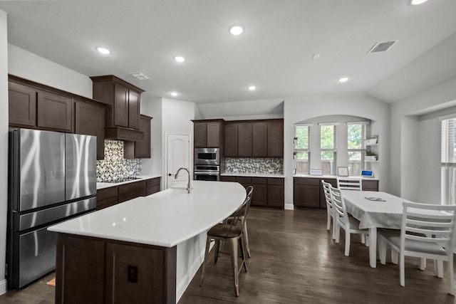 612 Wildriver Trl, Fort Worth, TX 76131 - kitchen with stainless steel appliances, a sink, dark brown cabinetry, a center island with sink, and light countertops