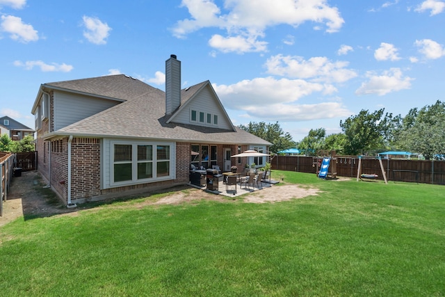 612 Wildriver Trl, Fort Worth, TX 76131 - rear view of house featuring a chimney, brick siding, a patio, roof with shingles, and a playground