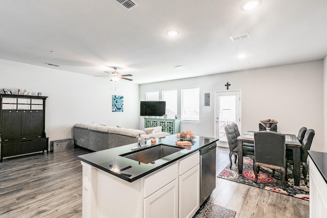 1129 Rusk Way, Lewisville, TX 75077 - kitchen with stainless steel dishwasher, dark countertops, light wood finished floors, open floor plan, and a sink