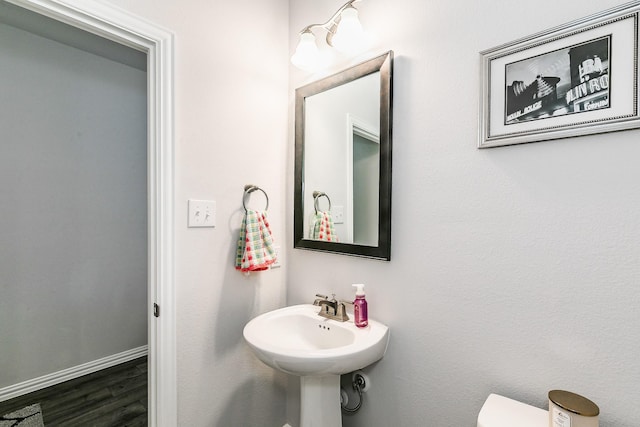 1129 Rusk Way, Lewisville, TX 75077 - bathroom featuring wood finished floors, baseboards, and toilet