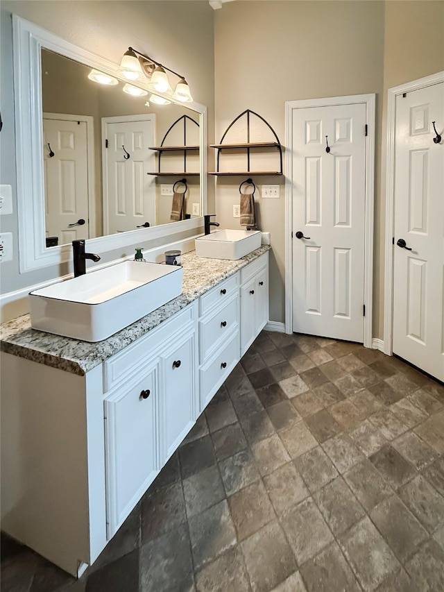 107 Summit Dr, Bossier City, LA 71111 - full bathroom with stone tile flooring, double vanity, and baseboards