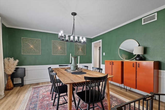 7204 Kingswood Dr, Fort Worth, TX 76133 - dining space featuring light wood-style floors, a chandelier, ornamental molding, and wainscoting
