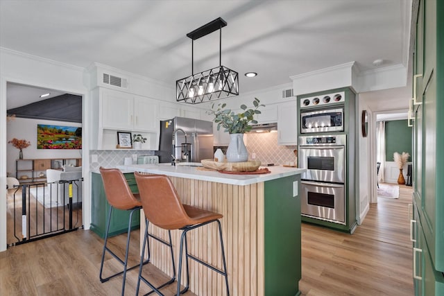 7204 Kingswood Dr, Fort Worth, TX 76133 - kitchen with appliances with stainless steel finishes, crown molding, decorative backsplash, a breakfast bar area, and light countertops