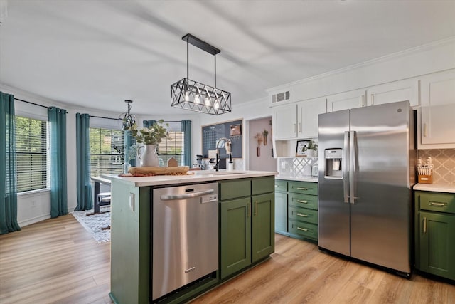 7204 Kingswood Dr, Fort Worth, TX 76133 - kitchen with green cabinets, appliances with stainless steel finishes, a sink, light countertops, and crown molding