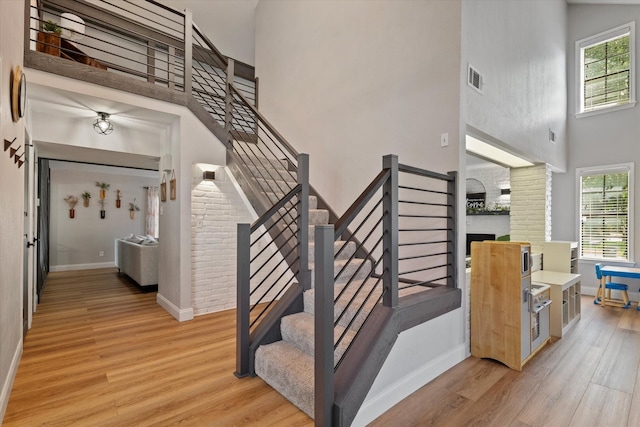 7204 Kingswood Dr, Fort Worth, TX 76133 - stairs with a high ceiling, wood finished floors, plenty of natural light, baseboards, and a large fireplace