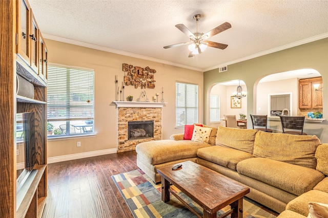 4406 Westcreek Ln, Sachse, TX 75048 - living room featuring arched walkways, a textured ceiling, a fireplace, ornamental molding, and hardwood / wood-style flooring