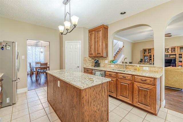 4406 Westcreek Ln, Sachse, TX 75048 - kitchen with appliances with stainless steel finishes, a sink, a center island, a chandelier, and arched walkways
