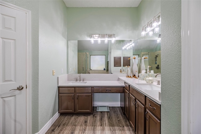 4406 Westcreek Ln, Sachse, TX 75048 - bathroom featuring a shower stall, double vanity, wood finished floors, baseboards, and a textured wall