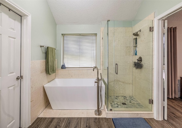 4406 Westcreek Ln, Sachse, TX 75048 - bathroom featuring a soaking tub, a shower stall, a textured ceiling, and wood finished floors