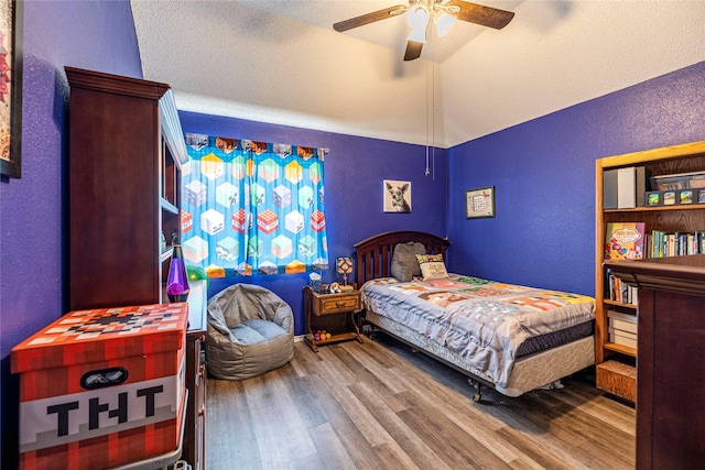 4406 Westcreek Ln, Sachse, TX 75048 - bedroom with a textured wall, wood finished floors, lofted ceiling, and a ceiling fan