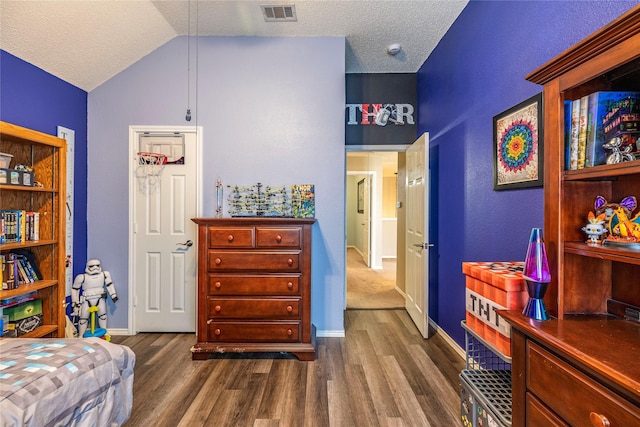 4406 Westcreek Ln, Sachse, TX 75048 - bedroom with dark wood-style flooring, baseboards, vaulted ceiling, and a textured ceiling