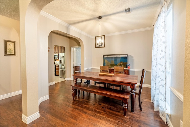 4406 Westcreek Ln, Sachse, TX 75048 - dining space featuring dark wood-type flooring, arched walkways, ornamental molding, a textured ceiling, and a chandelier