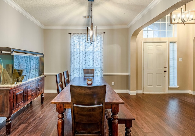 4406 Westcreek Ln, Sachse, TX 75048 - dining room with a chandelier, arched walkways, dark wood-style floors, ornamental molding, and a textured ceiling