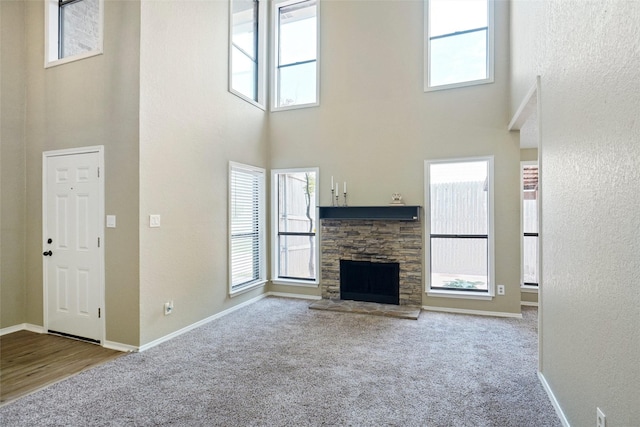 5630 Cancun Dr, North Richland Hills, TX 76180 - unfurnished living room with a towering ceiling, carpet floors, a fireplace, healthy amount of natural light, and baseboards