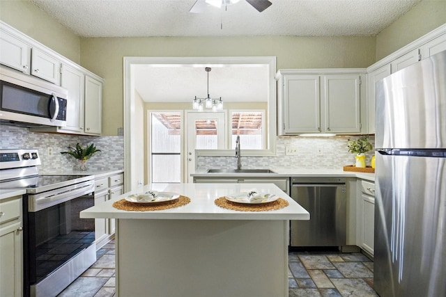 5630 Cancun Dr, North Richland Hills, TX 76180 - kitchen featuring appliances with stainless steel finishes, a sink, light countertops, stone tile floors, and a textured ceiling