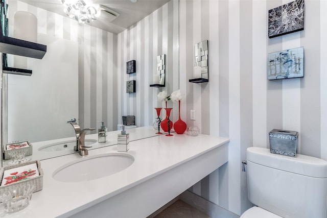 3111 Welborn St Unit 1303, Dallas, TX 75219 - bathroom with wallpapered walls, toilet, and vanity