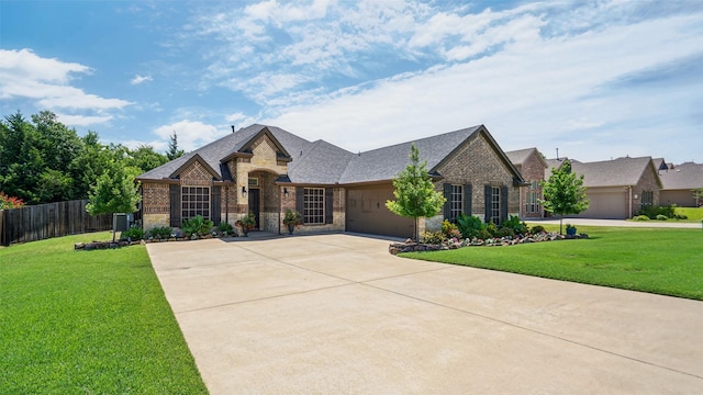 1530 Petaluma Dr, Rockwall, TX 75087 - french country style house featuring concrete driveway, brick siding, an attached garage, and stone siding