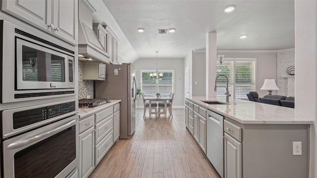 1530 Petaluma Dr, Rockwall, TX 75087 - kitchen with appliances with stainless steel finishes, a sink, custom exhaust hood, plenty of natural light, and ornamental molding