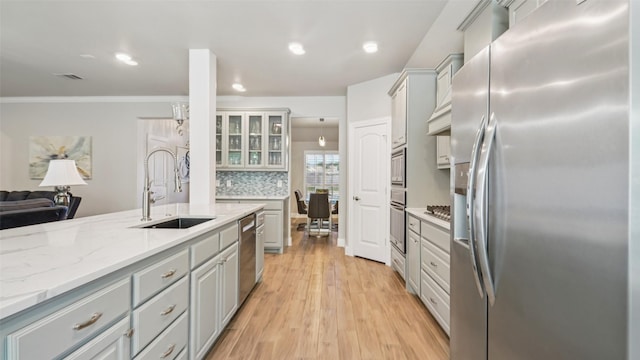 1530 Petaluma Dr, Rockwall, TX 75087 - kitchen with appliances with stainless steel finishes, a sink, gray cabinets, light wood-style floors, and crown molding