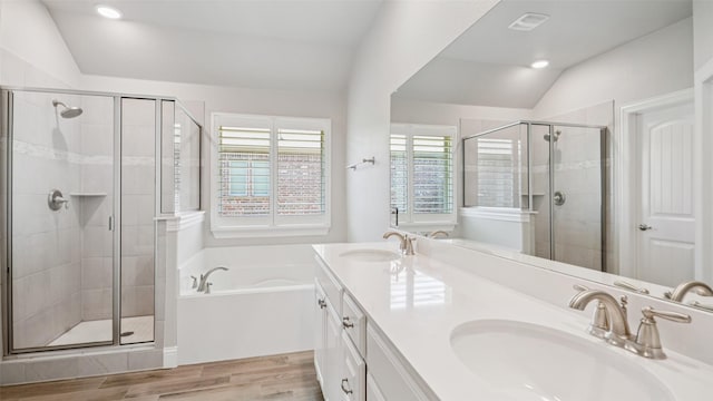 1530 Petaluma Dr, Rockwall, TX 75087 - bathroom featuring a garden tub, a stall shower, double vanity, lofted ceiling, and wood finished floors