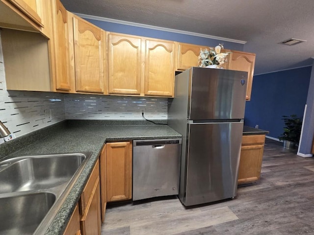 106 Mcanally Dr, Mabank, TX 75147 - kitchen with appliances with stainless steel finishes, a sink, decorative backsplash, crown molding, and wood finished floors