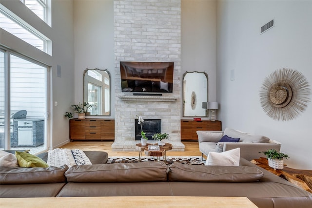 1328 Madeline Pl Unit B, Fort Worth, TX 76107 - living room featuring a brick fireplace, wood finished floors, and a towering ceiling
