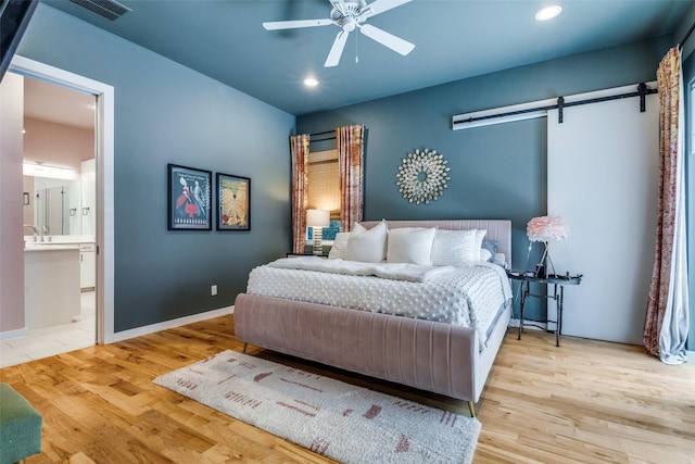 1328 Madeline Pl Unit B, Fort Worth, TX 76107 - bedroom with a barn door, wood finished floors, recessed lighting, ensuite bath, and ceiling fan
