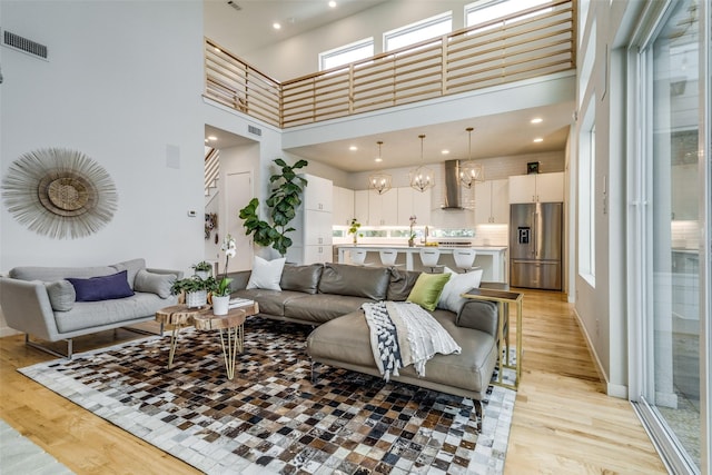 1328 Madeline Pl Unit B, Fort Worth, TX 76107 - living area with light wood finished floors, a towering ceiling, a chandelier, and recessed lighting