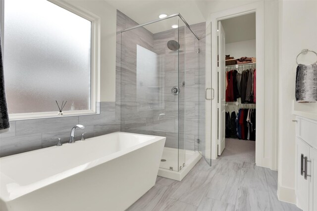 3728 Cherry Hills Dr, Sherman, TX 75090 - full bathroom with a freestanding bath, a shower stall, a walk in closet, marble finish flooring, and tile walls