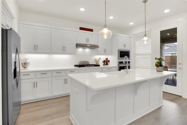 3728 Cherry Hills Dr, Sherman, TX 75090 - kitchen featuring appliances with stainless steel finishes, under cabinet range hood, light wood finished floors, tasteful backsplash, and recessed lighting