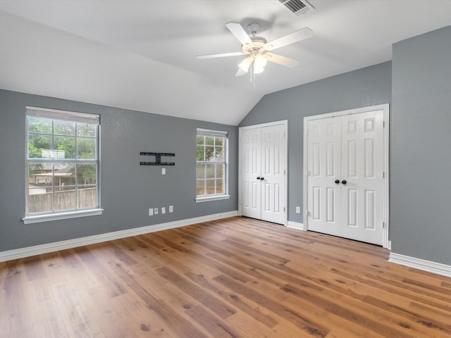 9120 Timber Oaks Dr, Fort Worth, TX 76179 - unfurnished bedroom featuring multiple closets, wood finished floors, lofted ceiling, baseboards, and ceiling fan