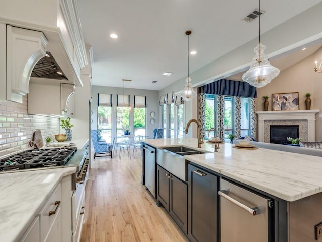 8542 Gerbera Daisy Rd, Frisco, TX 75035 - kitchen with white cabinets, light stone countertops, a kitchen island with sink, decorative backsplash, and recessed lighting