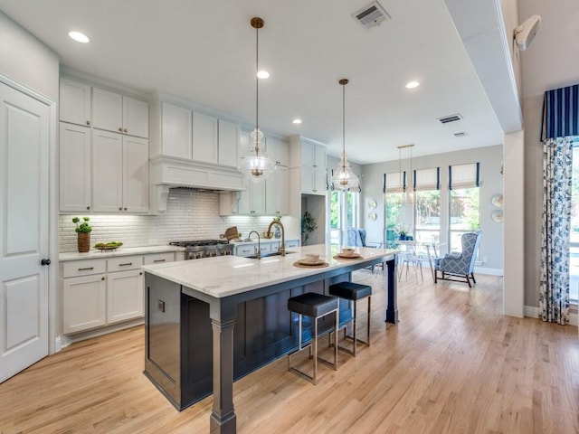 8542 Gerbera Daisy Rd, Frisco, TX 75035 - kitchen featuring decorative backsplash, light wood-type flooring, a kitchen bar, white cabinetry, and recessed lighting