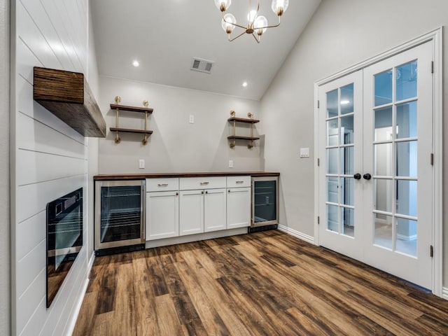 8542 Gerbera Daisy Rd, Frisco, TX 75035 - indoor dry bar with beverage cooler, dark wood-style floors, lofted ceiling, a chandelier, and recessed lighting