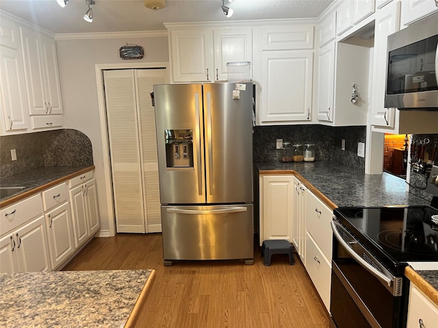 720 Robindale, Fairfield, TX 75840 - kitchen with stainless steel appliances, light wood-type flooring, white cabinets, and crown molding