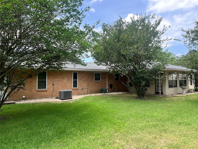 720 Robindale, Fairfield, TX 75840 - back of property featuring central AC, a lawn, and brick siding