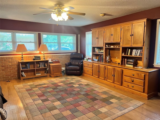 720 Robindale, Fairfield, TX 75840 - living area with ceiling fan, a textured ceiling, light wood-style flooring, and brick wall