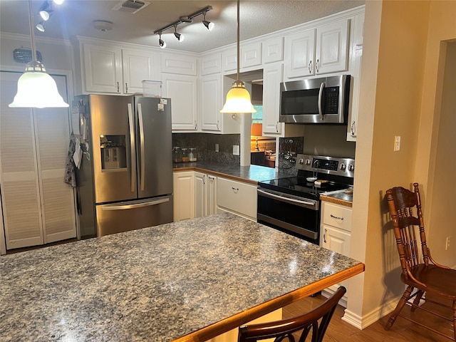 720 Robindale, Fairfield, TX 75840 - kitchen with stainless steel appliances, dark countertops, white cabinetry, a kitchen breakfast bar, and wood finished floors