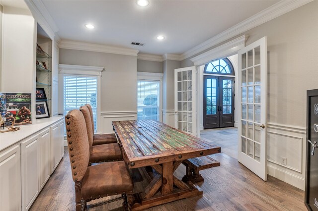 253 Bayne Rd, Haslet, TX 76052 - dining room with arched walkways, a chandelier, a decorative wall, light wood-type flooring, and crown molding