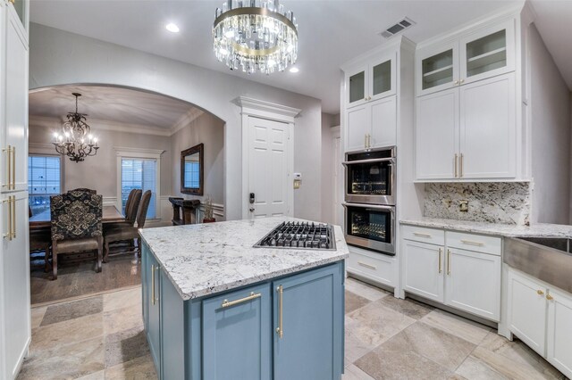 253 Bayne Rd, Haslet, TX 76052 - kitchen with stainless steel appliances, a center island, a peninsula, white cabinetry, and a chandelier